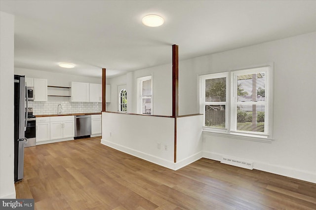 522 E Simpson St, Mechanicsburg, PA 17055 - kitchen featuring appliances with stainless steel finishes, white cabinets, light wood finished floors, and tasteful backsplash