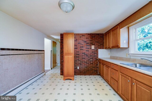 416 Colebrookdale Rd, Boyertown, PA 19512 - kitchen with brick wall, light floors, light countertops, brown cabinets, and a baseboard heating unit