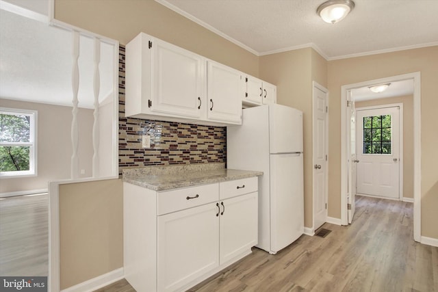 4953 Lincolnwood Dr, York, PA 17408 - kitchen featuring freestanding refrigerator, tasteful backsplash, white cabinetry, light wood-style flooring, and crown molding