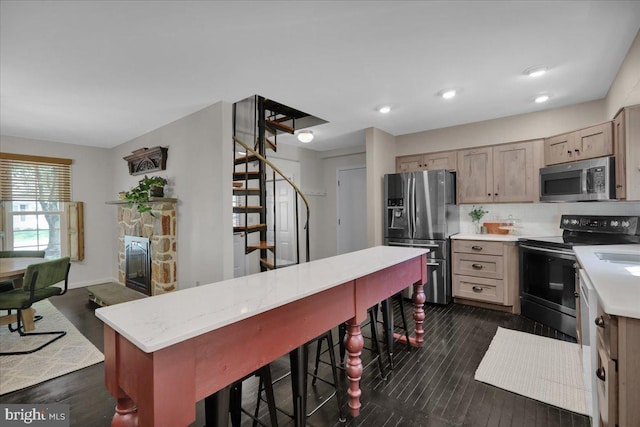 208 Queens Gate Rd, Lititz, PA 17543 - kitchen with appliances with stainless steel finishes, dark wood-style floors, tasteful backsplash, a stone fireplace, and recessed lighting