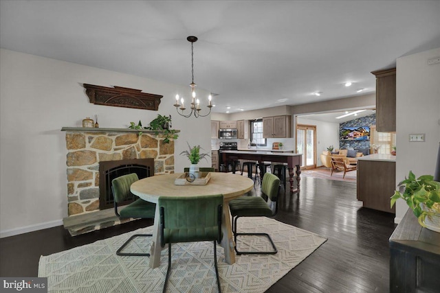 208 Queens Gate Rd, Lititz, PA 17543 - dining area with a chandelier, a stone fireplace, dark wood-style floors, and recessed lighting