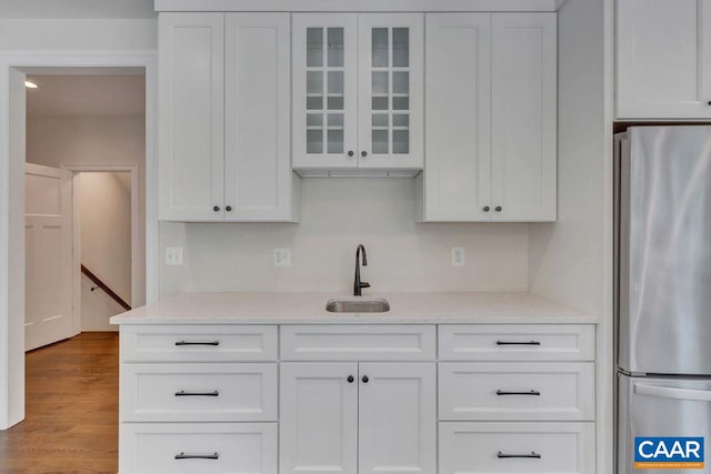 3 Rothwell Ln Lot 3, Crozet, VA 22932 - kitchen with freestanding refrigerator, glass insert cabinets, white cabinetry, light stone countertops, and wood finished floors