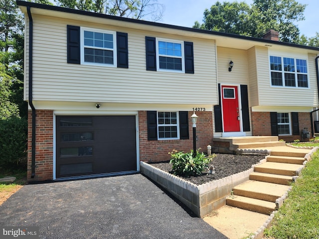 14273 Princedale Dr, Woodbridge, VA 22193 - raised ranch with a garage, brick siding, driveway, and a chimney