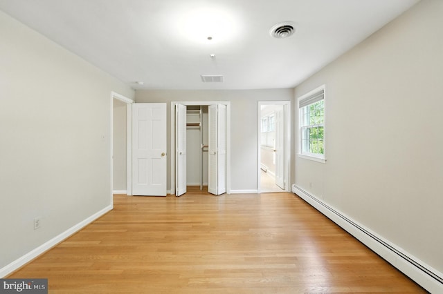 508 Vierling Dr, Silver Spring, MD 20904 - unfurnished bedroom featuring baseboard heating, light wood-style floors, a closet, and connected bathroom