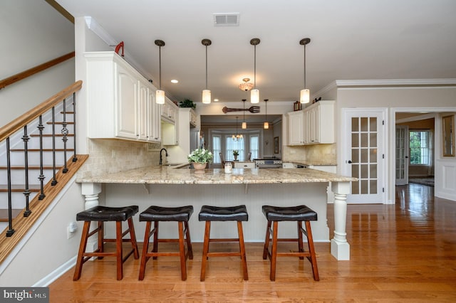 12 Deerpath Ln, Columbus, NJ 08022 - kitchen featuring a peninsula, a kitchen breakfast bar, crown molding, tasteful backsplash, and light wood-style flooring