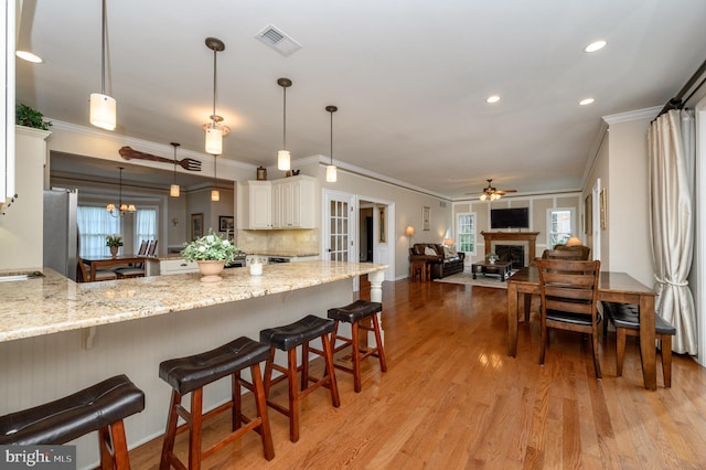 12 Deerpath Ln, Columbus, NJ 08022 - kitchen with ornamental molding, freestanding refrigerator, a peninsula, light wood finished floors, and a breakfast bar area