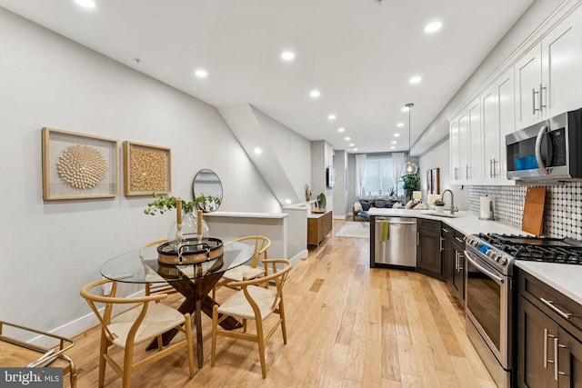 614 I St NE Unit 1, Washington, DC 20002 - kitchen featuring appliances with stainless steel finishes, light countertops, recessed lighting, white cabinets, and light wood-type flooring