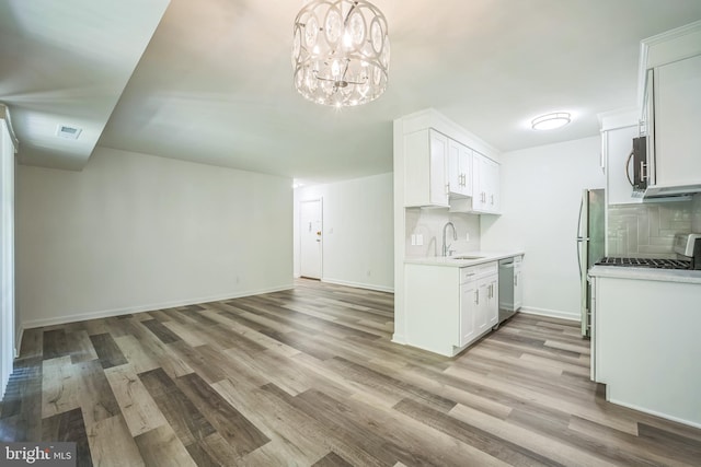 4939 Americana Dr Unit 106, Annandale, VA 22003 - kitchen with stainless steel appliances, light wood-type flooring, light countertops, tasteful backsplash, and white cabinetry