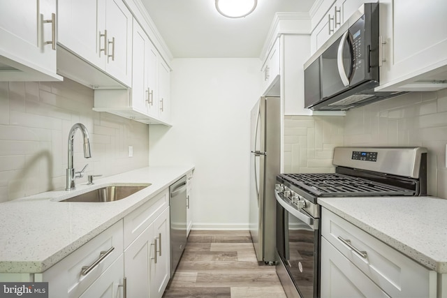 4939 Americana Dr Unit 106, Annandale, VA 22003 - kitchen with stainless steel appliances, backsplash, light wood-type flooring, and white cabinetry