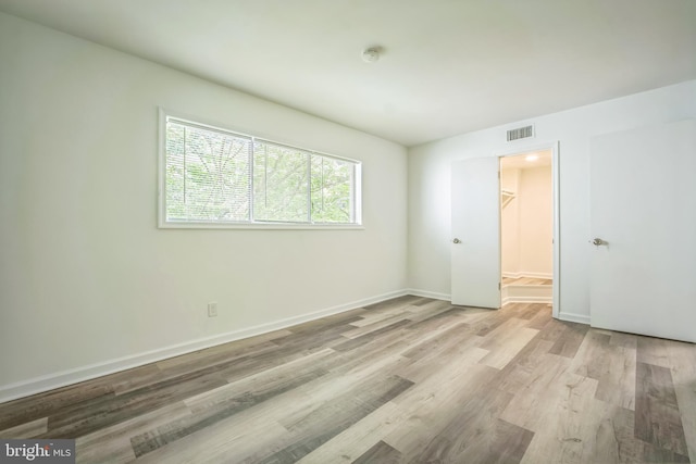 4939 Americana Dr Unit 106, Annandale, VA 22003 - unfurnished bedroom featuring wood finished floors, a walk in closet, and a closet