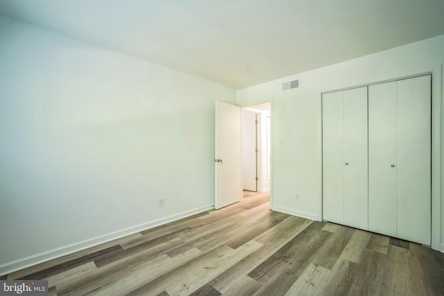 4939 Americana Dr Unit 106, Annandale, VA 22003 - unfurnished bedroom featuring wood finished floors and a closet