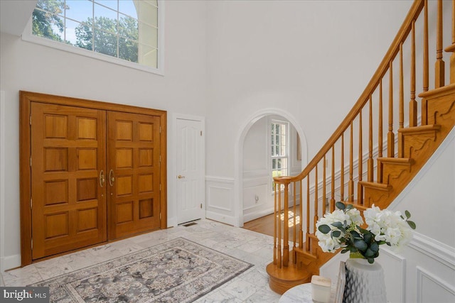 15506 Avery Rd, Rockville, MD 20855 - entryway with healthy amount of natural light, a towering ceiling, marble look tile flooring, stairway, and arched walkways