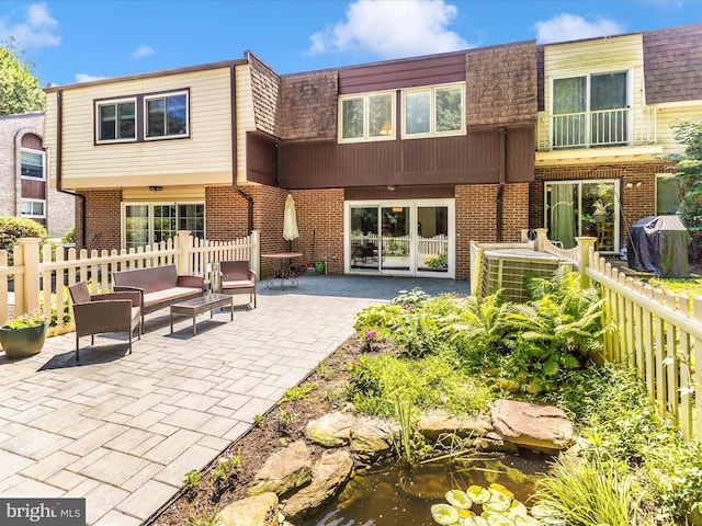 12263 Greenleaf Ave, Potomac, MD 20854 - rear view of property with a patio, brick siding, and an outdoor living space