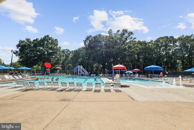 906 Danton Ln, Alexandria, VA 22308 - community pool featuring a patio area and view of wooded area