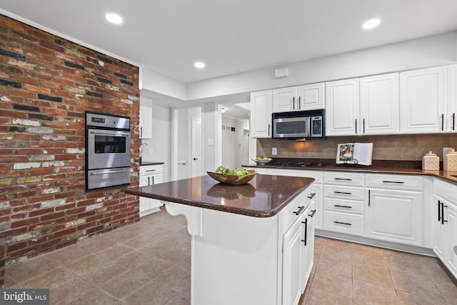 906 Danton Ln, Alexandria, VA 22308 - kitchen featuring appliances with stainless steel finishes, a warming drawer, light tile patterned floors, backsplash, and recessed lighting