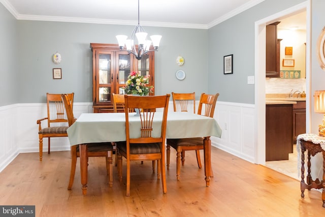 1338 Chami Dr Unit 196, Spring Grove, PA 17362 - dining area featuring a chandelier, light wood-style floors, a wainscoted wall, crown molding, and a decorative wall