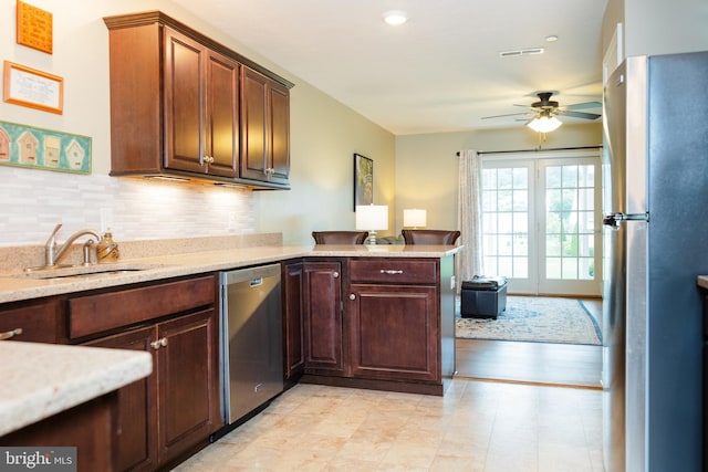 1338 Chami Dr Unit 196, Spring Grove, PA 17362 - kitchen with stainless steel appliances, a ceiling fan, decorative backsplash, a peninsula, and light stone countertops