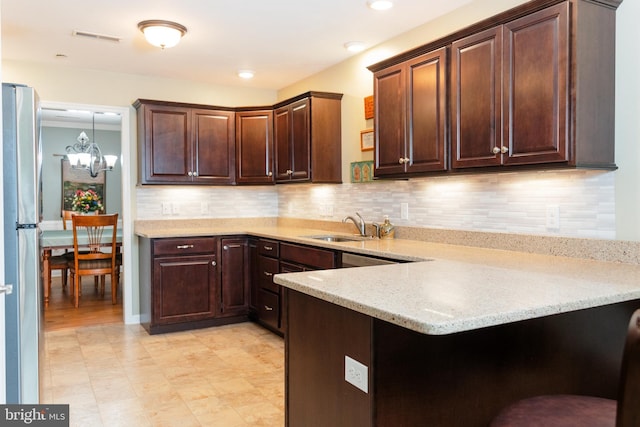 1338 Chami Dr Unit 196, Spring Grove, PA 17362 - kitchen with freestanding refrigerator, a peninsula, dark brown cabinetry, backsplash, and a chandelier