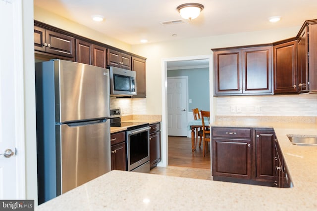 1338 Chami Dr Unit 196, Spring Grove, PA 17362 - kitchen with appliances with stainless steel finishes, decorative backsplash, dark brown cabinetry, light stone countertops, and recessed lighting