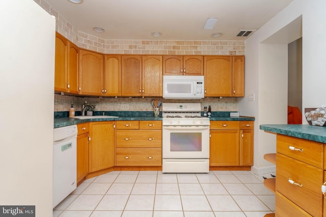 2302 Searles Rd, Dundalk, MD 21222 - kitchen featuring white appliances, backsplash, dark countertops, and brown cabinetry