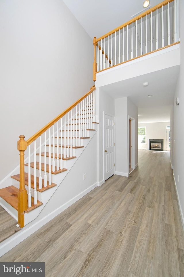 304 Amy Way, Cinnaminson, NJ 08077 - stairway featuring wood finished floors, a high ceiling, and a glass covered fireplace