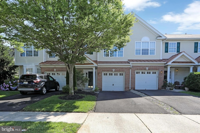 304 Amy Way, Cinnaminson, NJ 08077 - townhome / multi-family property featuring brick siding, a garage, driveway, a standing seam roof, and a metal roof
