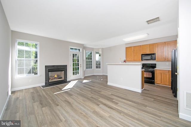304 Amy Way, Cinnaminson, NJ 08077 - unfurnished living room with light wood-style floors, healthy amount of natural light, and a warm lit fireplace