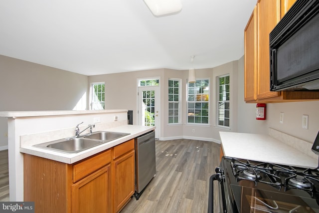 304 Amy Way, Cinnaminson, NJ 08077 - kitchen with black appliances, light wood-style flooring, light countertops, an island with sink, and brown cabinetry