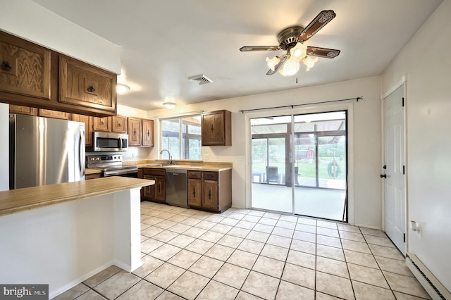 4604 View Dr, Spring Grove, PA 17362 - kitchen with appliances with stainless steel finishes, a baseboard heating unit, light countertops, ceiling fan, and light tile patterned flooring