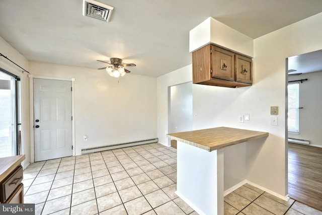 4604 View Dr, Spring Grove, PA 17362 - kitchen with a baseboard heating unit, ceiling fan, light tile patterned flooring, and brown cabinetry