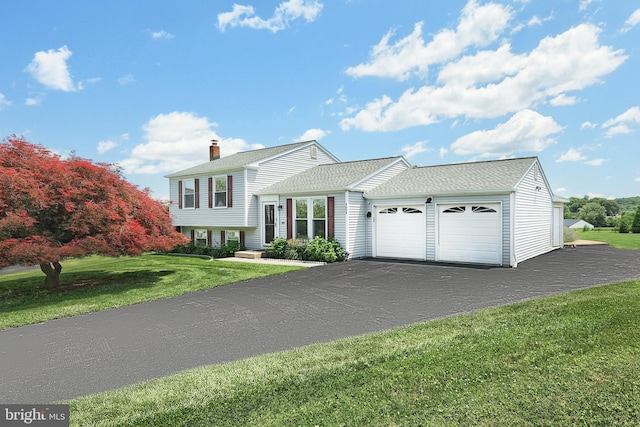 4604 View Dr, Spring Grove, PA 17362 - split level home featuring an attached garage, a front lawn, a chimney, driveway, and a shingled roof