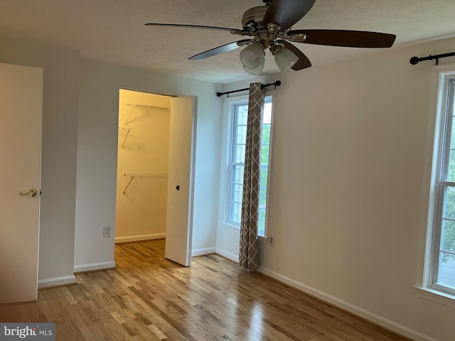 18327 Ivy Oak Ter, Gaithersburg, MD 20877 - unfurnished bedroom featuring light wood-type flooring, multiple windows, a spacious closet, and a closet