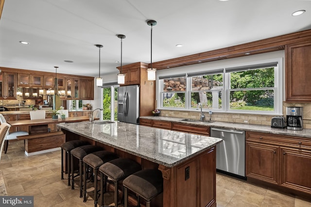 295 Crescent Ave, Moorestown, NJ 08057 - kitchen featuring appliances with stainless steel finishes, backsplash, an island with sink, a kitchen bar, and glass insert cabinets