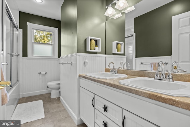 295 Crescent Ave, Moorestown, NJ 08057 - full bath with wainscoting, double vanity, bath / shower combo with glass door, and stone finish floors