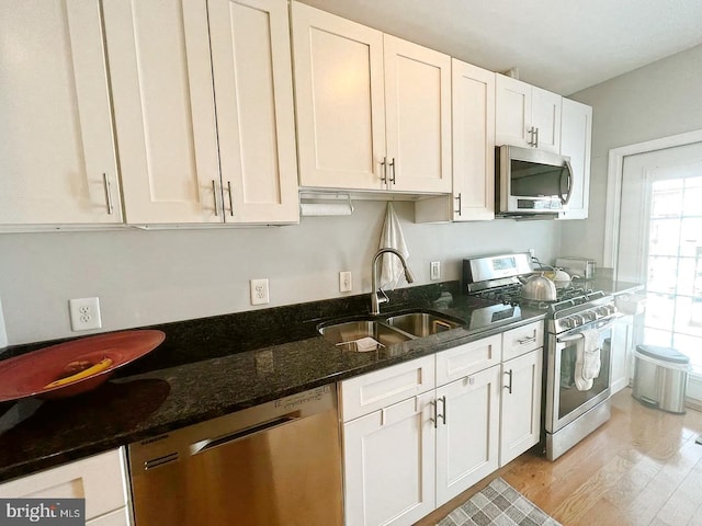 445 Manor Pl NW Unit 3, Washington, DC 20010 - kitchen with stainless steel appliances, light wood-style flooring, white cabinetry, and dark stone countertops