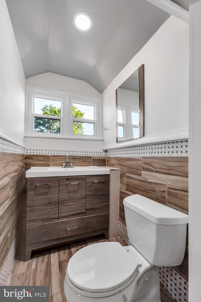 100 Powelton Ave, Lansdowne, PA 19050 - bathroom with tile walls, vanity, vaulted ceiling, a wainscoted wall, and wood finished floors