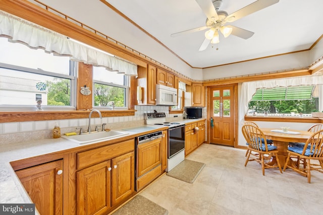 615 Convent Rd, Aston, PA 19014 - kitchen with white appliances, light countertops, brown cabinets, crown molding, and tasteful backsplash