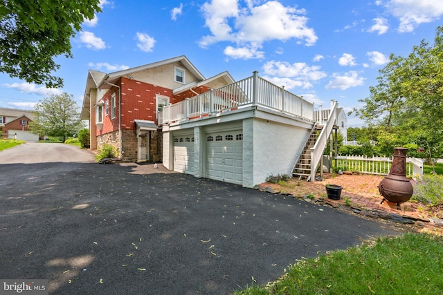 615 Convent Rd, Aston, PA 19014 - view of side of home with driveway, stairway, brick siding, and a deck