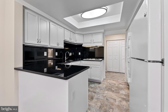3622 Gleneagles Dr Unit 9-2C, Silver Spring, MD 20906 - kitchen with white appliances, dark countertops, a peninsula, and a tray ceiling