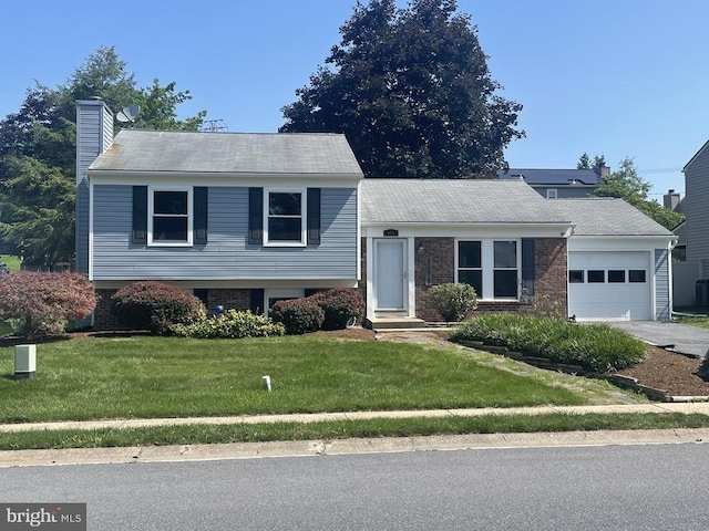 171 Tanglewood Ln, Lancaster, PA 17601 - split level home featuring a garage, a chimney, a front lawn, and brick siding
