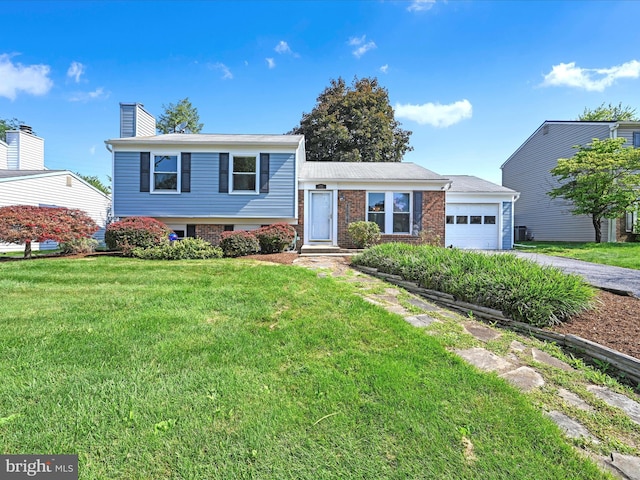 171 Tanglewood Ln, Lancaster, PA 17601 - split level home featuring asphalt driveway, a front yard, an attached garage, a chimney, and brick siding