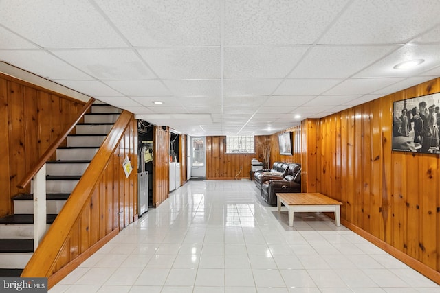 2847 S 65th St, Philadelphia, PA 19142 - basement with stairway, wooden walls, a drop ceiling, and light tile patterned flooring