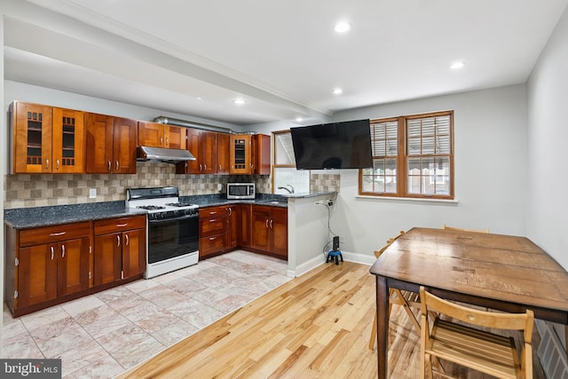 2847 S 65th St, Philadelphia, PA 19142 - kitchen featuring white gas range oven, under cabinet range hood, stainless steel microwave, recessed lighting, and backsplash