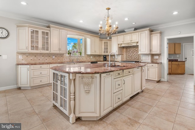 3213 Hatton Rd, Baltimore, MD 21208 - kitchen featuring cream cabinets, a chandelier, a center island with sink, crown molding, and backsplash