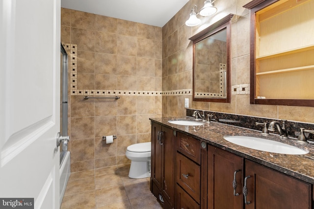 3213 Hatton Rd, Baltimore, MD 21208 - bathroom with tile walls, double vanity, tile patterned flooring, and shower / bath combination with glass door