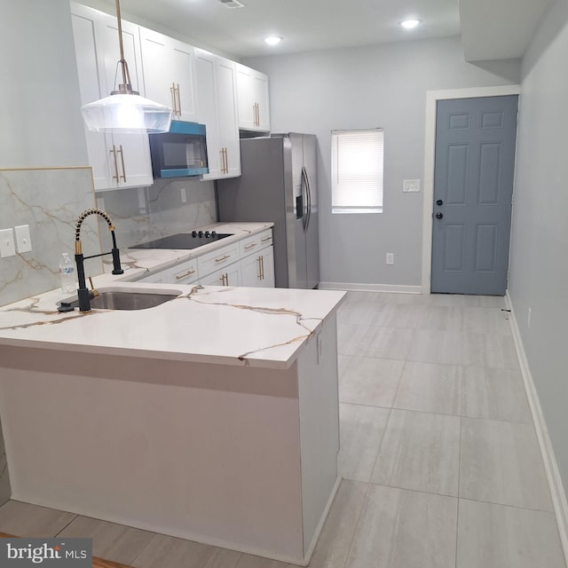 1716 N Monroe St, Baltimore, MD 21217 - kitchen with black appliances, white cabinetry, a peninsula, light stone counters, and recessed lighting