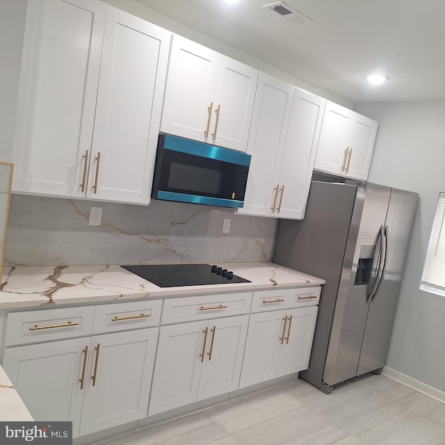 1716 N Monroe St, Baltimore, MD 21217 - kitchen featuring stainless steel fridge, black electric stovetop, white cabinets, backsplash, and light stone counters