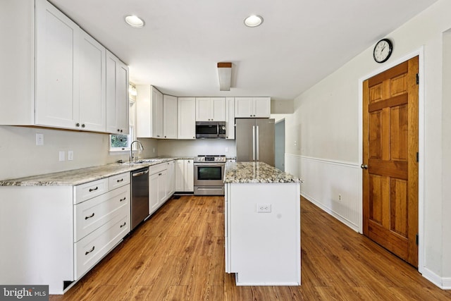 1207 Avalon Blvd, Shady Side, MD 20764 - kitchen with stainless steel appliances, a kitchen island, white cabinets, light wood-type flooring, and recessed lighting