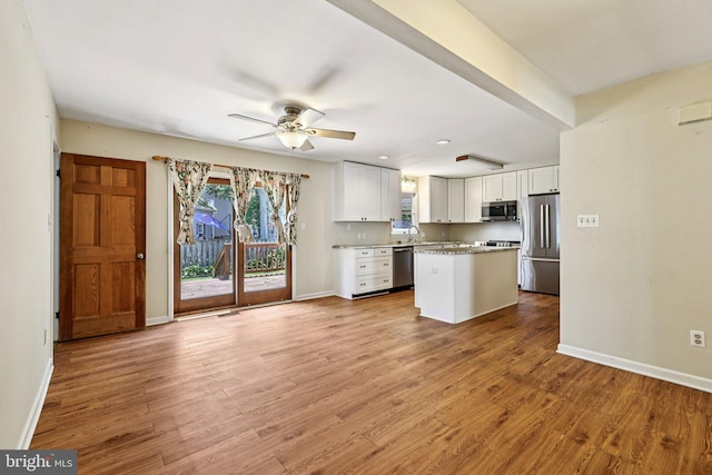 1207 Avalon Blvd, Shady Side, MD 20764 - kitchen featuring appliances with stainless steel finishes, white cabinets, ceiling fan, light wood-type flooring, and a kitchen island