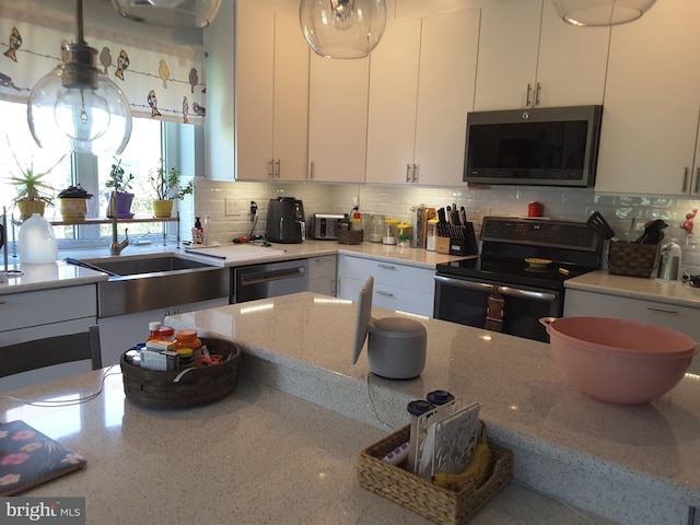 295 Bridgewater Cir, Fredericksburg, VA 22406 - kitchen with appliances with stainless steel finishes, white cabinets, backsplash, and light stone countertops